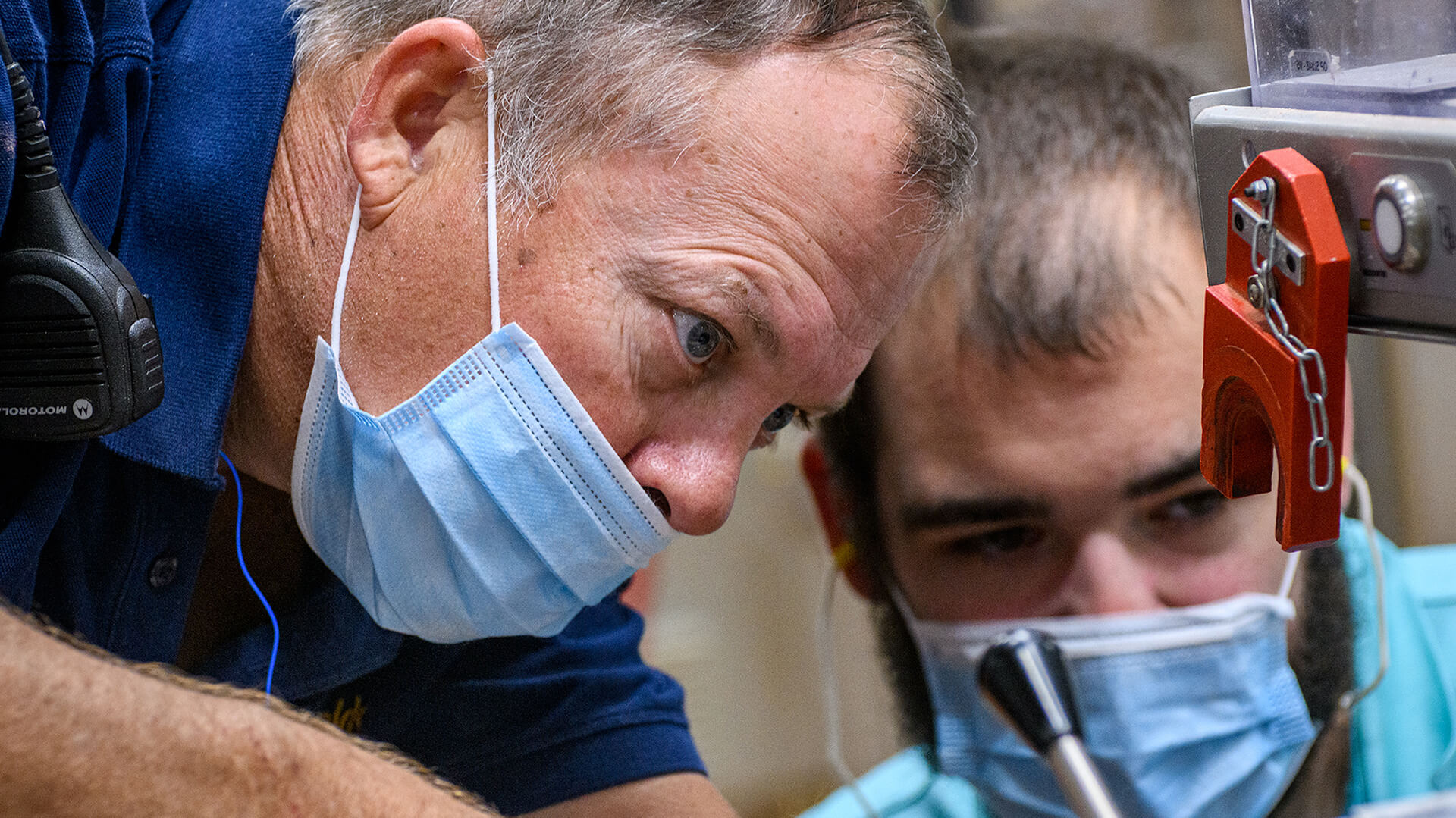 two men wearing face masks working